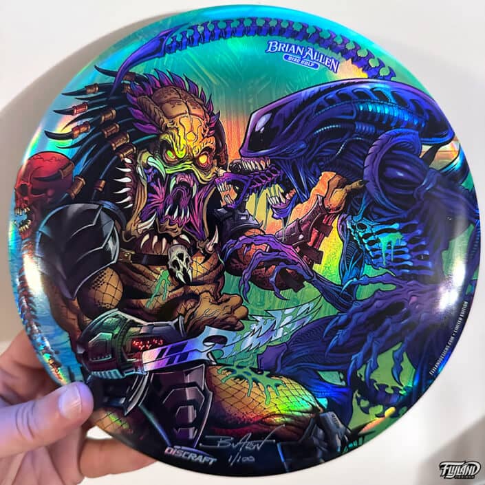 Illustration of Alien and Predator fighting each other on a disc golf disc