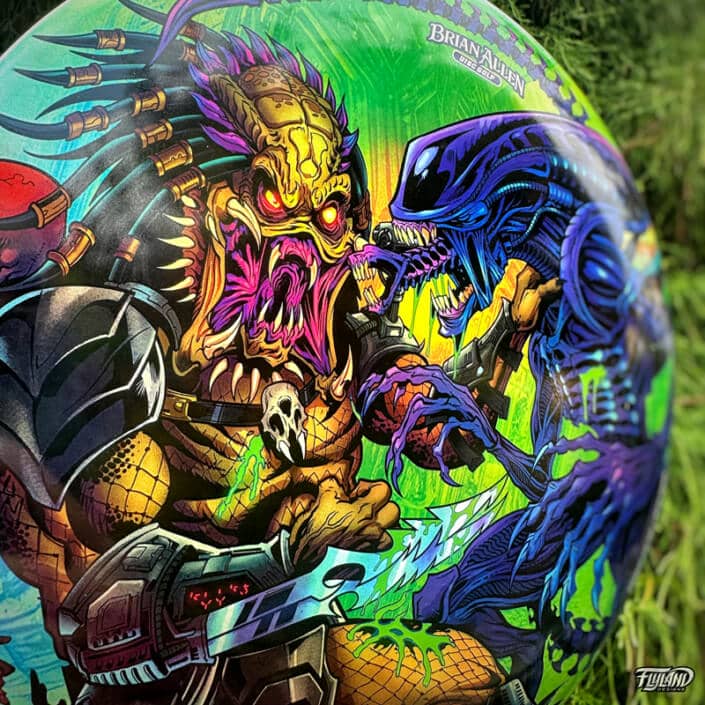 Illustration of Alien and Predator fighting each other on a disc golf disc