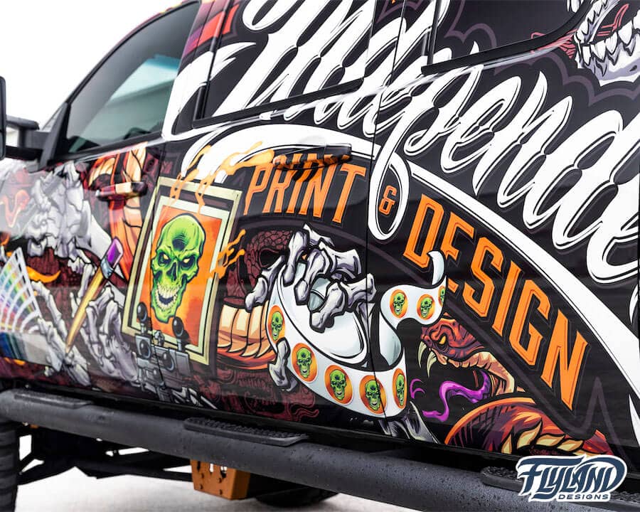 A vehicle wrap decorating a truck with Skull and wings, and skeleton with wrapping tools and materials drawn for a truck vehicle vinyl wrap
