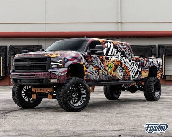 A vehicle wrap decorating a truck with Skull and wings, and skeleton with wrapping tools and materials drawn for a truck vehicle vinyl wrap
