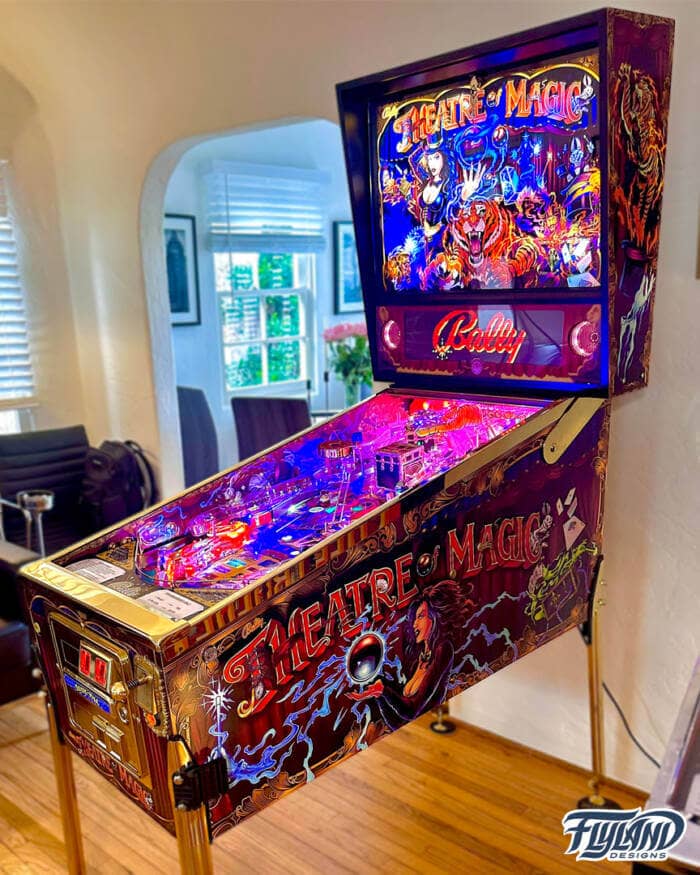 Theather of Magic Vinyl wrap for Pinball Machines artwork by Brian Allen. A magical illsutration with a woman holding a magic ball,. there are playing cards trunks with chains and wrabbis coming out of hats.